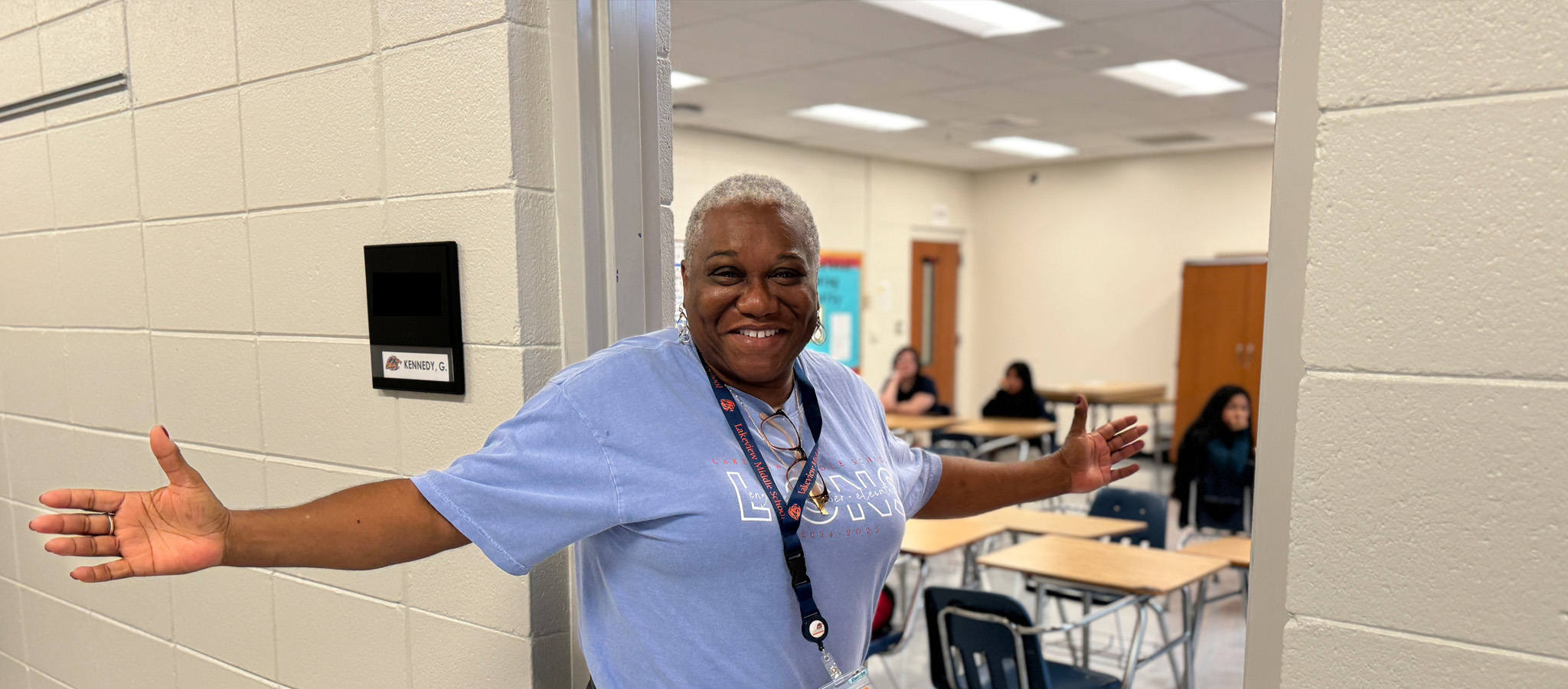 Student smiling in classroom with a backpack